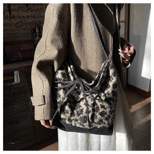 Detail view of leopard print plush tote bag with a bow accent and Cool lettering