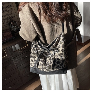 Detail of leopard print faux fur tote bag with black bow and white embroidery