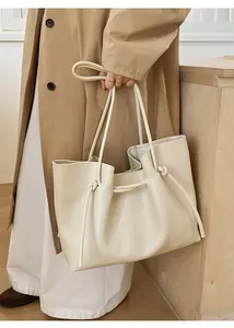 Detail of knotted shoulder straps and soft cream PU leather on large tote bag