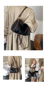 Detail view of a minimalist black and brown backpack with elegant gold metal hardware