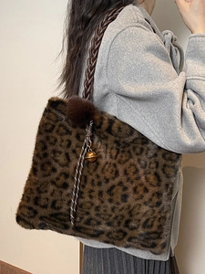 Faux fur leopard print tote bag with woven shoulder strap and decorative charm