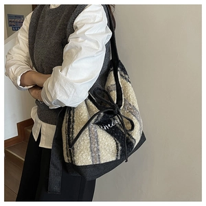 Detail of fuzzy faux fur tote bag with striped texture and embroidered side drawstring