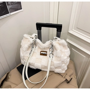 Dettaglio della borsa tote in peluche con trama a scacchi e tracolla a catena d'argento