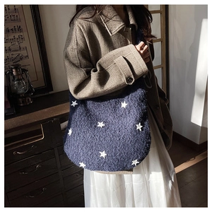 Blue fuzzy star pattern tote bag in plush material shown in a retro lifestyle setting