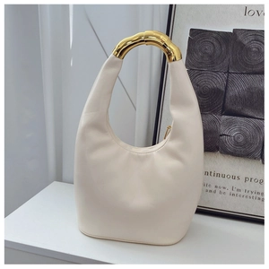 Detail of minimalist cream hobo bag featuring a distinctive chunky gold metal handle