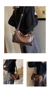 Detail view of the vintage brown leather Boston bag with contrast black straps and gold buckle