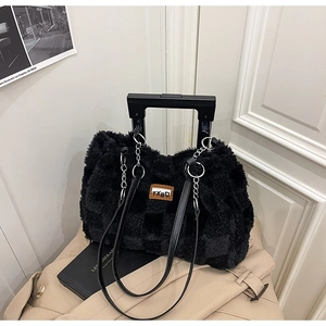 Dettaglio borsa tote in peluche a scacchi con catena argento e logo su cappotto beige