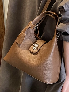 Brown litchi grain leather bucket bag with silver turn-lock and adjustable shoulder strap