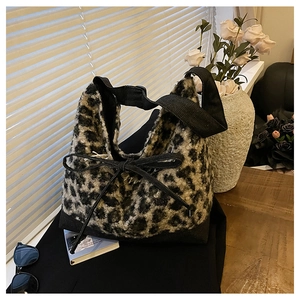 Detailed macro view of soft leopard print faux fur tote bag with decorative black bow