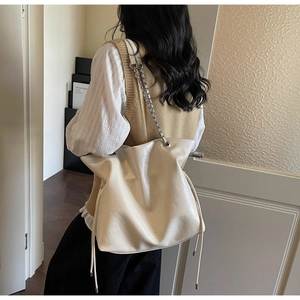 Close-up of cream white soft PU leather tote bag with silver chain strap and drawstring