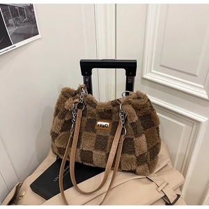 Dettaglio della borsa tote in peluche a scacchi marroni con spalline in pelle e catena