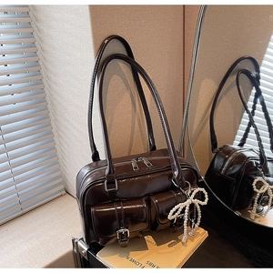Detailed view of coffee brown faux leather bag featuring double pockets and silver zippers