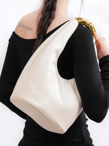Minimalist cream shoulder bag with unique gold asymmetric metal handle for women