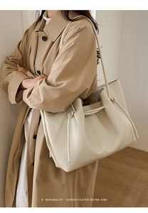 Chic cream leather tote bag shown on shoulder with minimalist retro styling for work