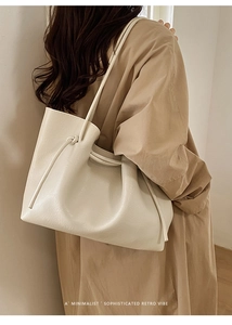 Detail of minimalist beige leather tote bag with side knot and drawstring closure