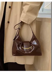 Détail du sac baguette vintage en cuir ciré marron foncé avec boucle en métal doré chic