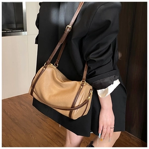 Detail of vintage Boston bag showing golden hardware and adjustable brown shoulder strap