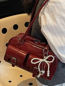 Retro burgundy shoulder bag with front buckle pockets and pearl bow charm detail