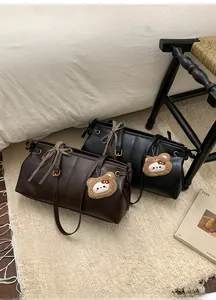 Detail of Boston tote bag featuring plaid ribbon bows and cute plush bear charms