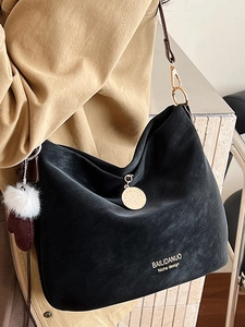 Minimalist black suede hobo bag with white lettering and plush ball pendant for women