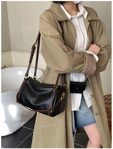 Detail of a vintage black Boston bag with brown leather strap and gold hardware