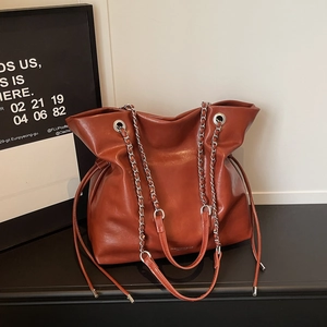Close-up of caramel vintage tote with silver chain strap and fashion embossed logo