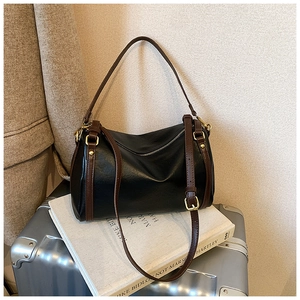 Detail of retro Boston bag with black leather and brown straps on a metallic suitcase
