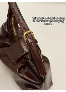 Gros plan du sac baguette vintage marron foncé avec fermetures et sangle réglable