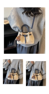 Detail of canvas bucket bag featuring navy leather handles and vintage styling
