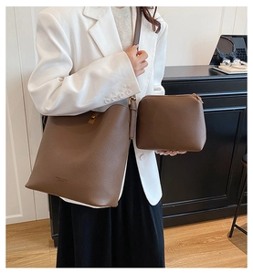 Brown leather bucket bag set with adjustable strap and metal buckle lock shown in interior
