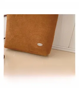 Macro detail of brown faux suede shoulder bag featuring a minimalist silver metal plaque
