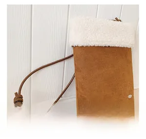 Detail of winter crossbody bag featuring brown suede texture and plush faux shearling trim