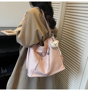 Vue détaillée du sac cabas en similicuir rose avec fermeture éclair et breloque ours en peluche