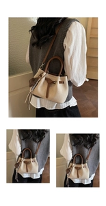 Detail of canvas bucket bag with brown leather trim, strap and woven tassel ornament