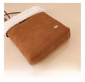 Detail showing the contrast stitching and plush faux fur trim on a suede crossbody bag