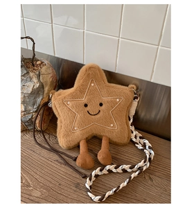 Détail d'un sac bandoulière en peluche en forme d'étoile avec visage brodé et sangle