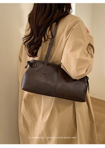 Detail shot of a vintage brown leather shoulder bag on a model with a minimalist retro vibe