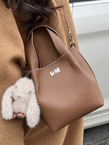 Brown litchi leather bucket bag with silver clasp and plush rabbit pendant detail