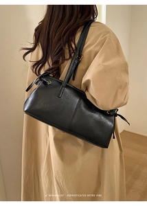 Minimalist black leather tote bag with gold hardware and side knot detail on model shoulder