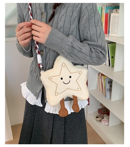 Détail du sac à bandoulière en peluche en forme d'étoile avec un visage souriant