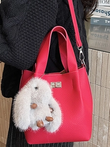 Chic rose red pebble leather bucket bag with silver twist lock and plush rabbit charm