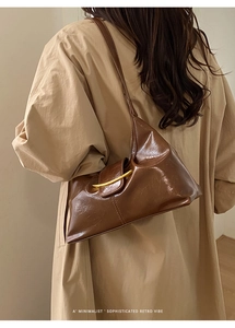 Détail du sac porté épaule rétro en cuir ciré marron foncé avec boucle dorée en croissant