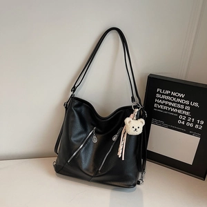 Détails du sac cabas en similicuir noir avec fermetures éclair et un pendentif ours en peluche