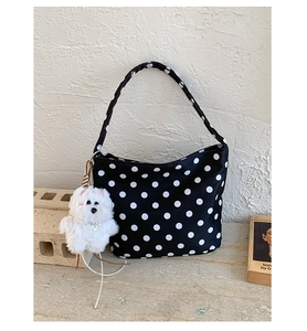 Détail du sac à main à pois noirs et blancs avec charmant pendentif chien en peluche