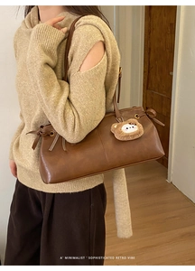 Brown faux leather shoulder bag with side bow detail and plush bear charm pendant