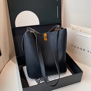 Detail view of black lychee grain leather bucket bag in a luxury gift box packaging
