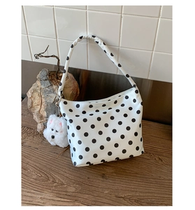 Détail du sac sous le bras à pois blancs avec charmant pendentif chiot en peluche