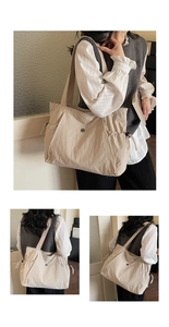Detail view of large capacity beige nylon tote bag showing side drawstrings and round clasp