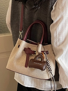 Vintage canvas bucket bag with burgundy leather trim and adjustable crossbody strap