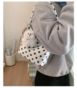 Détail du sac à bandoulière blanc à pois avec un pendentif en peluche pour chien